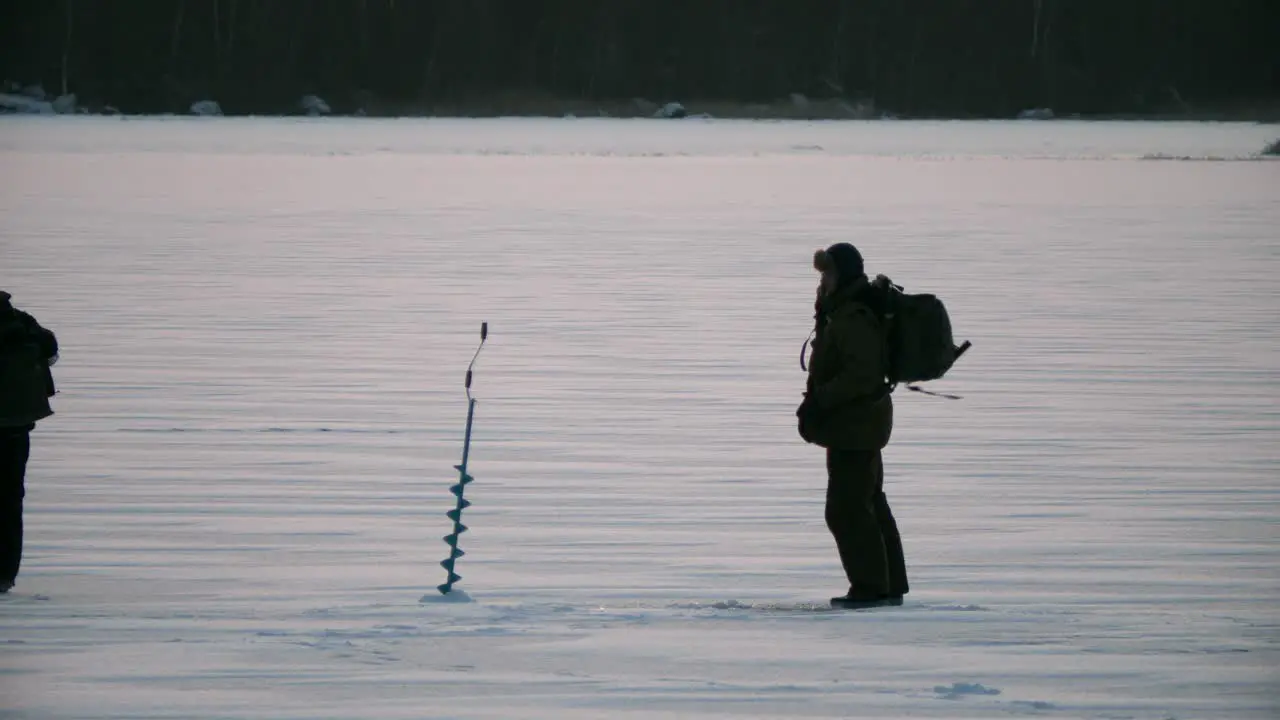 Winter scene Men walking on ice for winter fishing in arctic frost slow motion