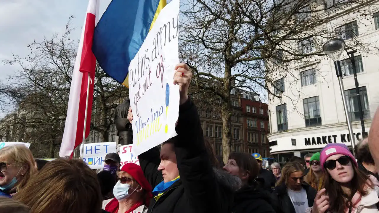 Patriotic female with Putin message at Ukraine anti war protest activists on Manchester city street