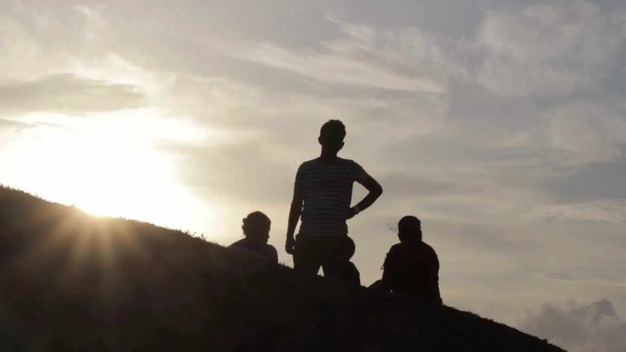 Silhouette of a happy family relaxing on the open grass field in Galle Fort evening sun glare consept of a vacation and family time