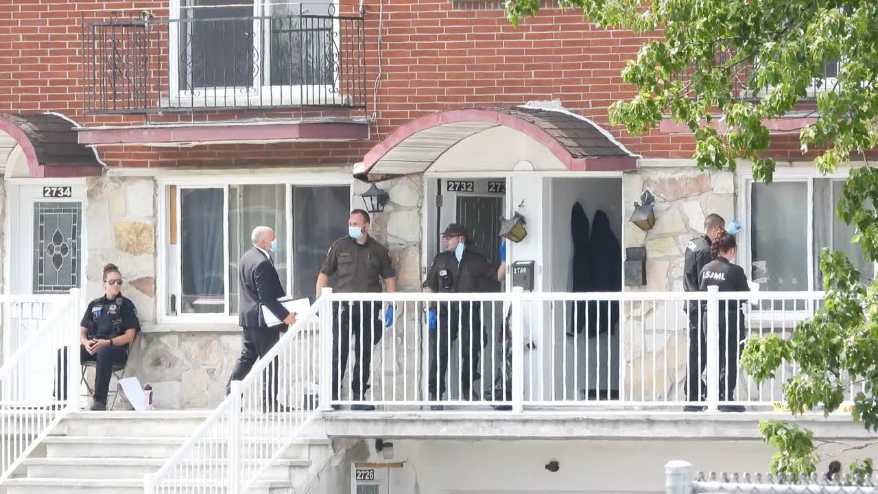 Police officers investigate crime scene on Residential Building Longueuil