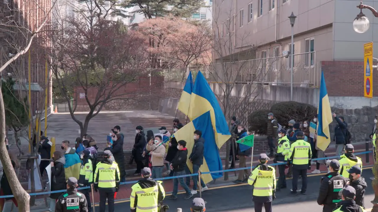 Ukrainians Protesters march against the Russian invasion of Ukraine in Seoul walking with flags and Posters towards Russian embassy