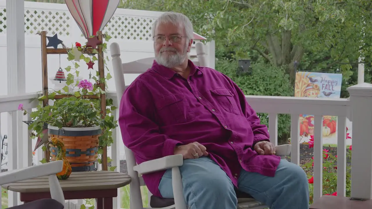 A Senior Male Resting in a Rocking Chair on a Deck Enjoying His Retirement on a Autumn Day