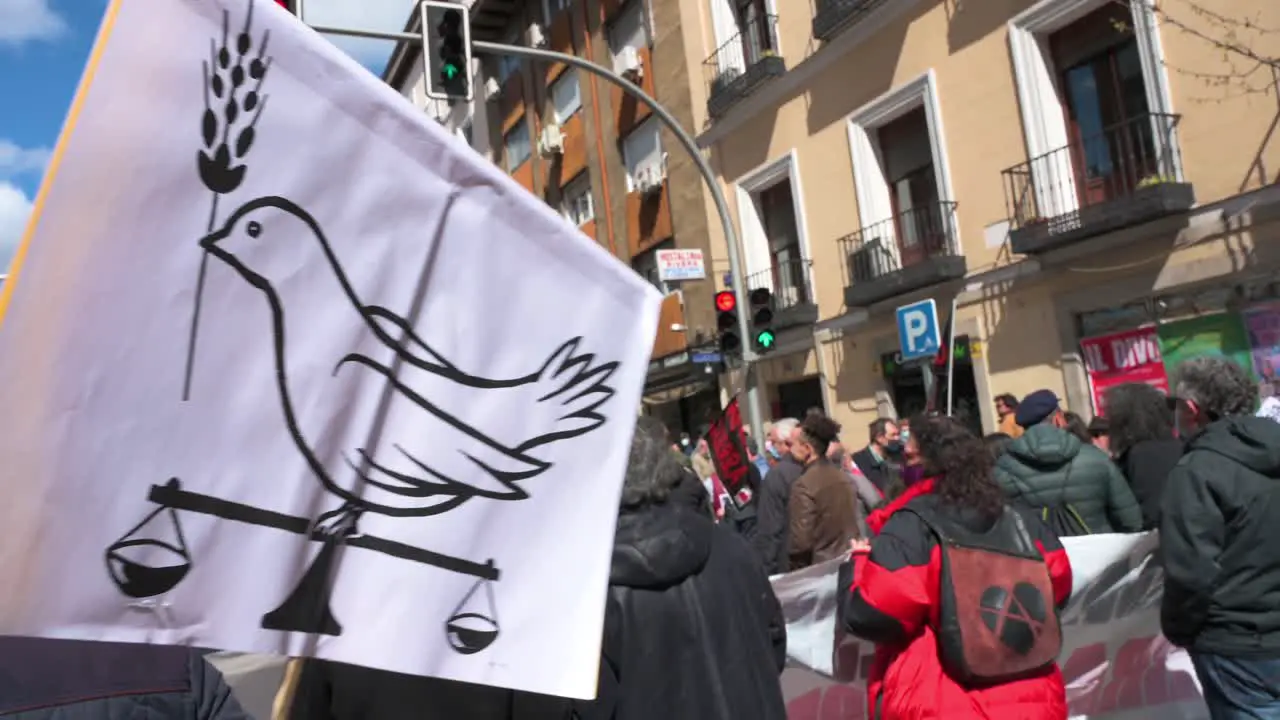 A protestor holds a placard with a drawing depicting a dove of peace during a demonstration against the Ukraine war and NATO's 'imperialist expansionism' role in Madrid Spain