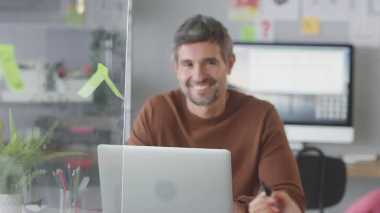 Businesswoman In Creative Office Writing Ideas On Transparent Screen Talking To Male Colleague