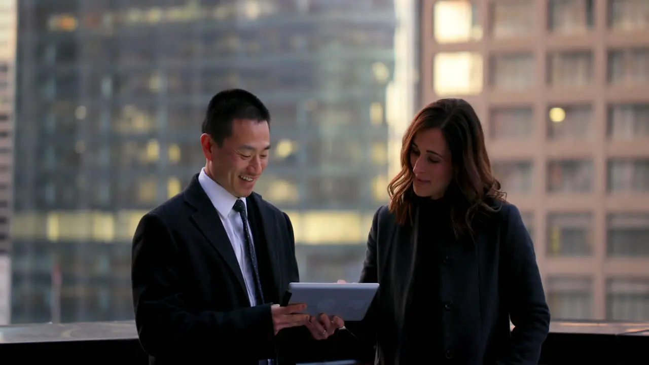 Front view of mixed race business people discussing over digital tablet 4k