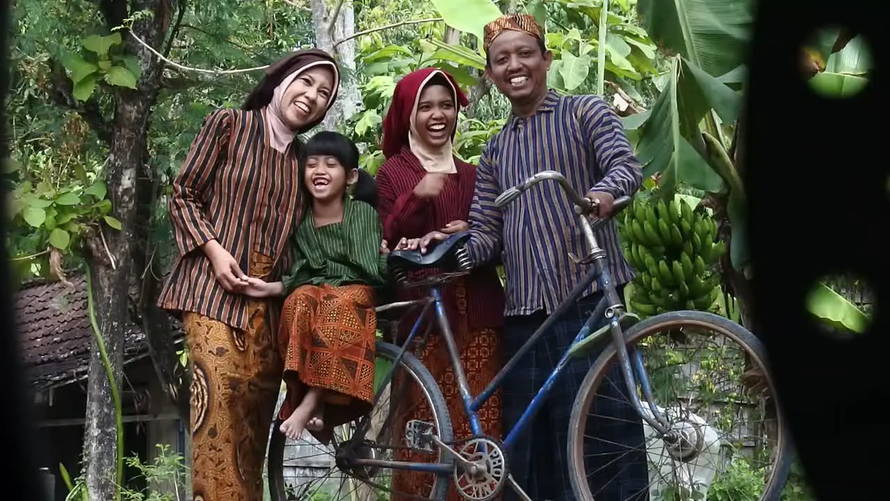 A happy Javanese family with their two children on an ancient bicycle Central Java Indonesia