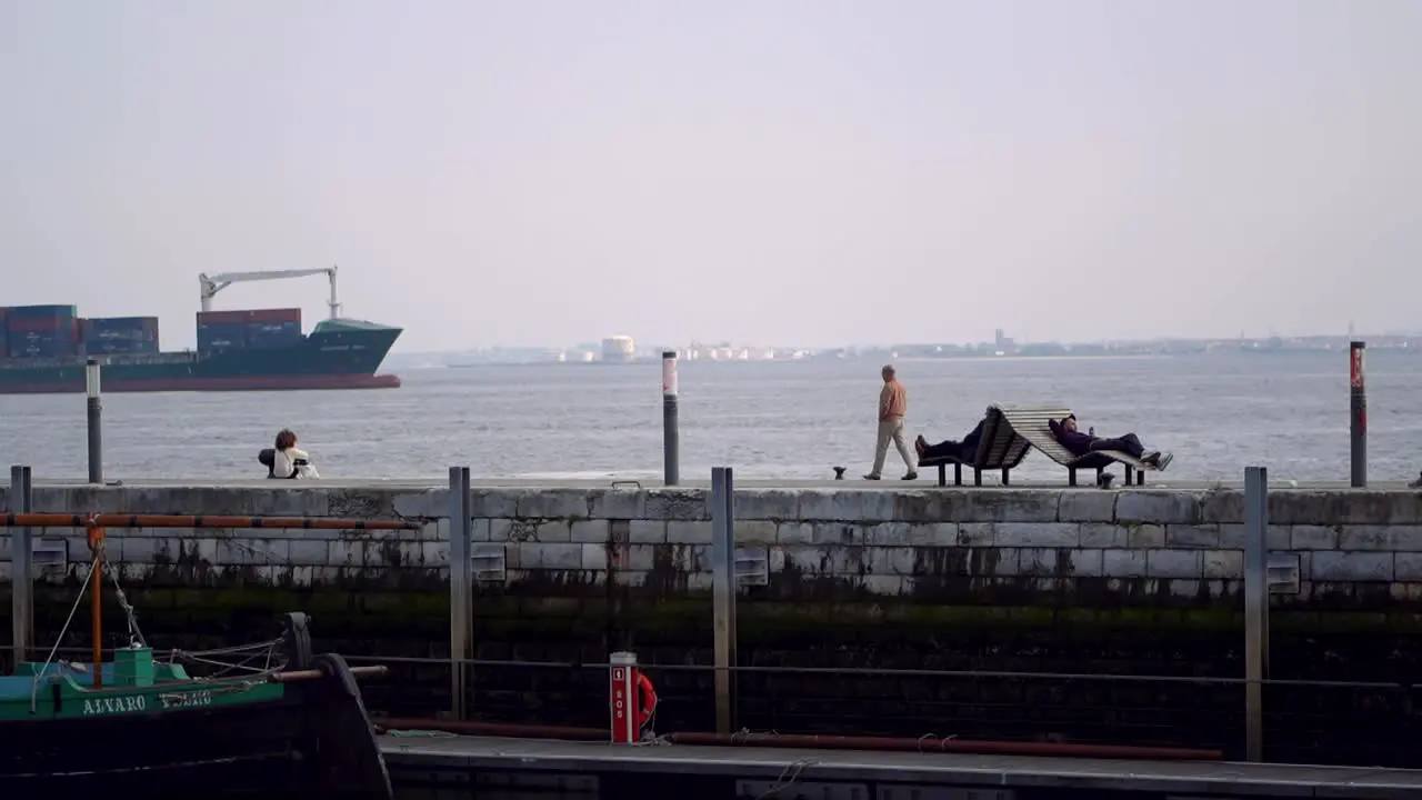 Tourists relaxing and strolling at Water break promenade cityscape in the distance