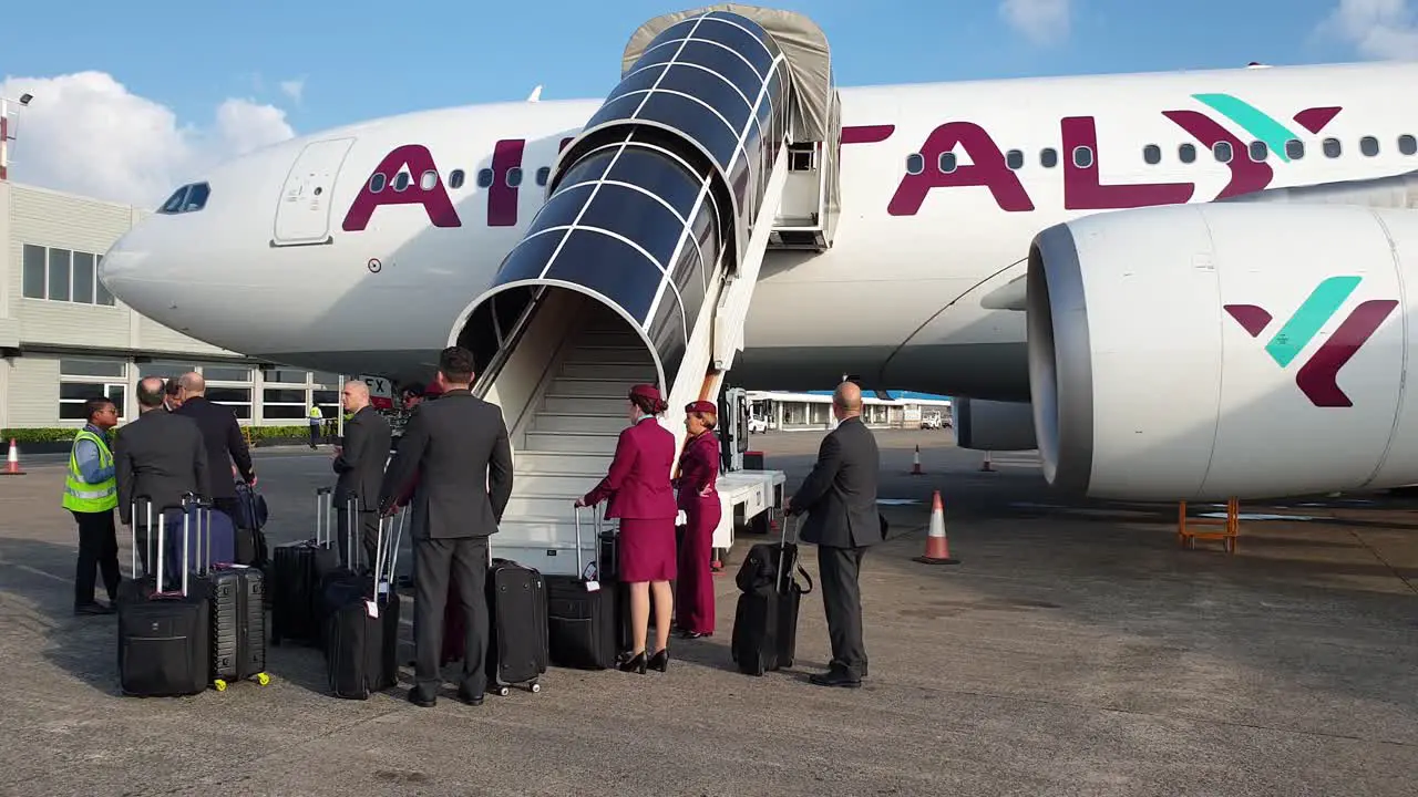 Cabin crew with uniform and baggages under airplane