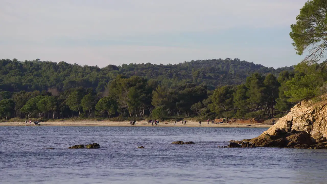 Crowd of people hiking on path along the mediterranean sea called "sentier littoral" or "sentier des douaniers"