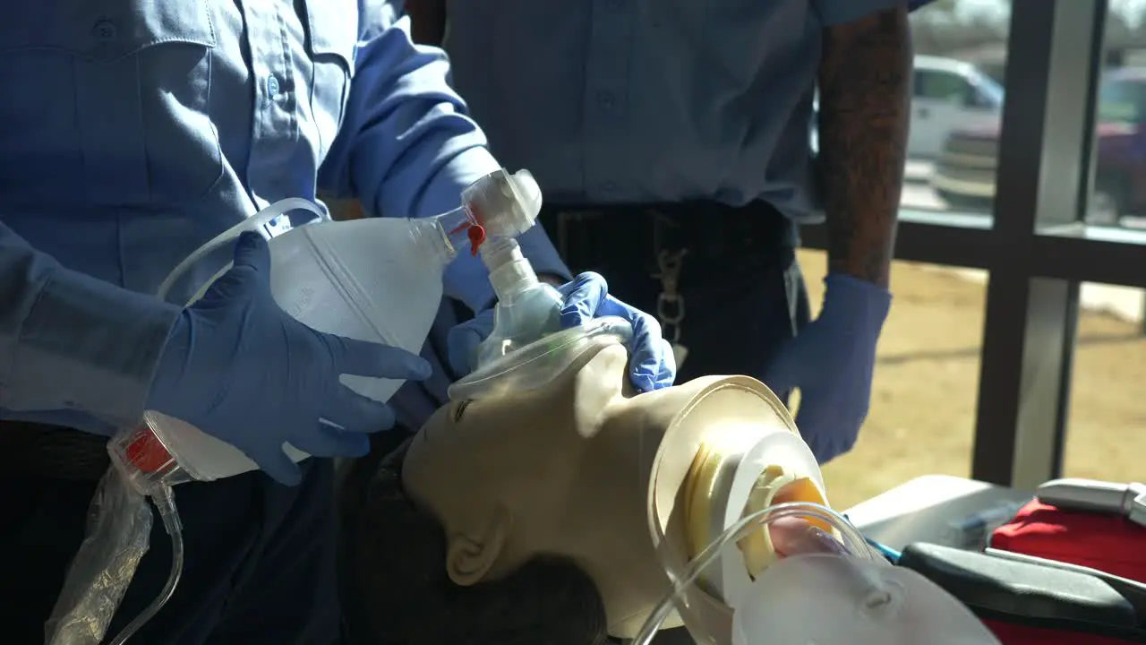 Medical technician practices medical resuscitation treatment on a human dummy with an air bag