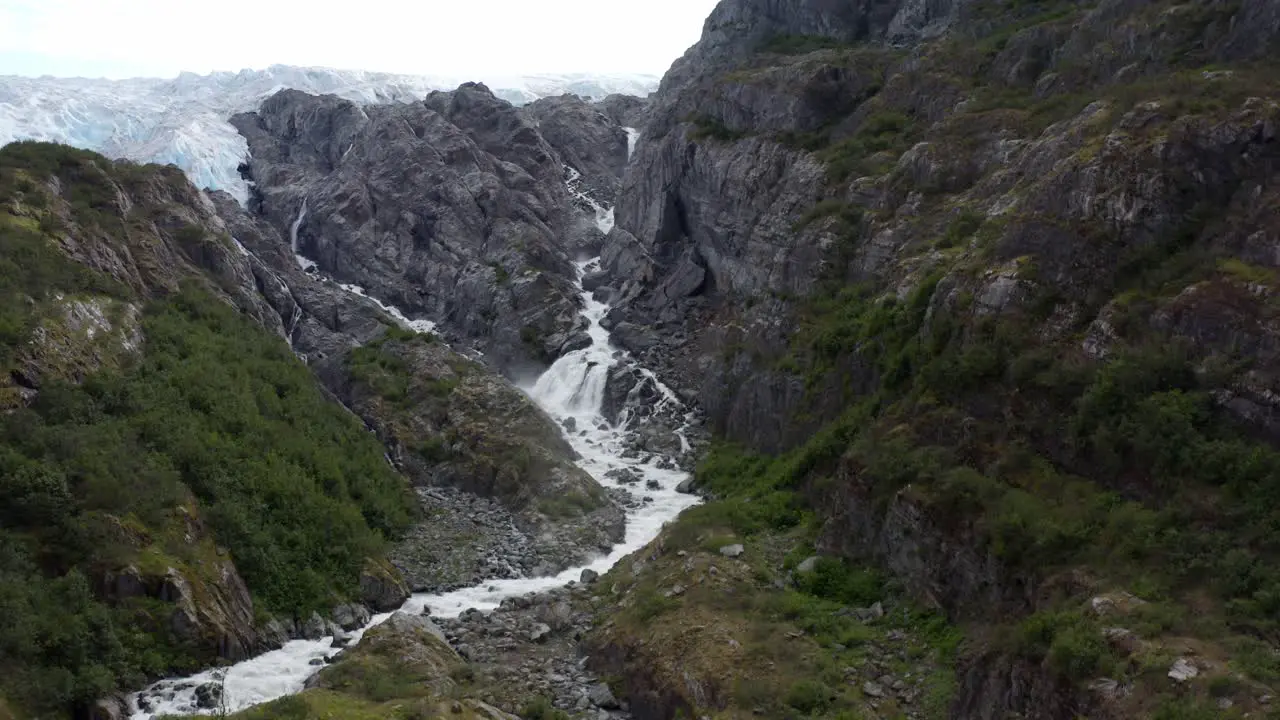 White stream falls from the snowy mountains of Alaska -aerial