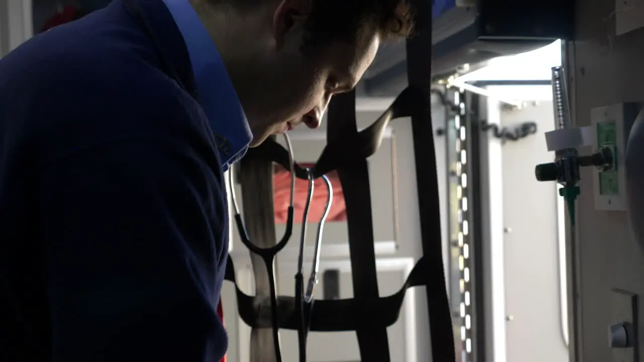 Emergency medical technician prepares medic gear inside an ambulance to be ready for emergency response