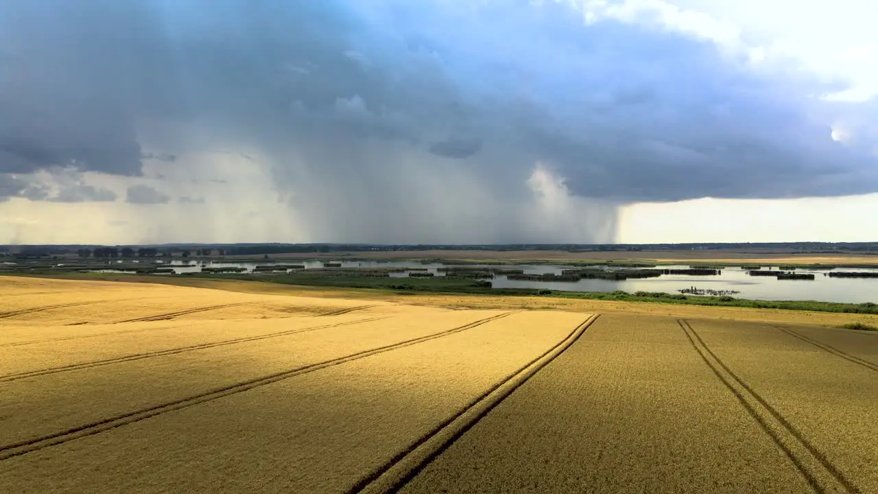 Aerial shot of a farm field with a storm in distance