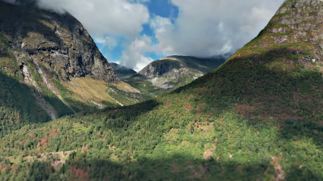 Aerial hyperlapse shot of a Norvegian mountain valley with clouds whirling over the tops