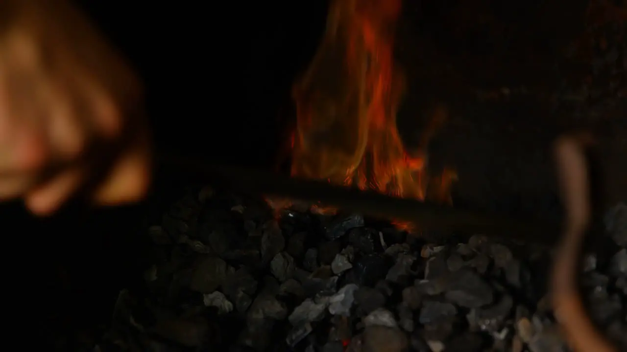 Metalsmith heating horseshoe in fire 4k