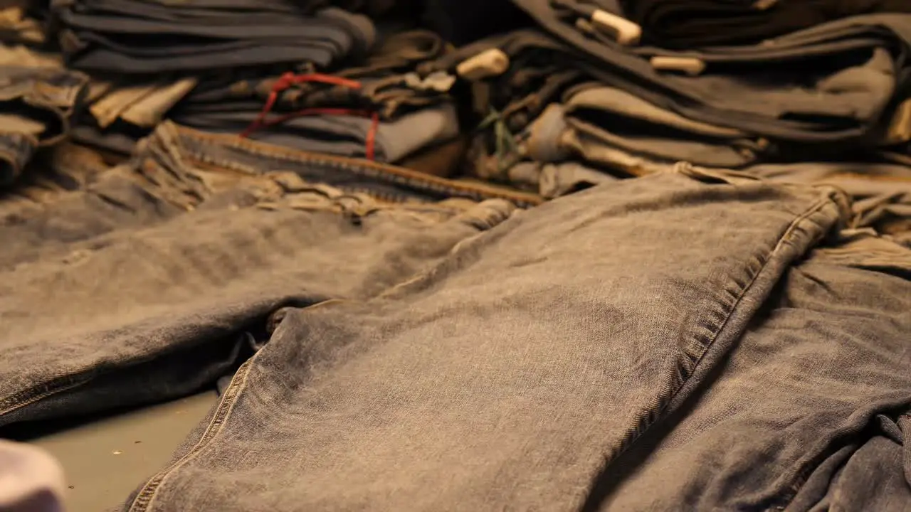 Quality Control Check On Jeans Under Light In Factory By Worker In Pakistan