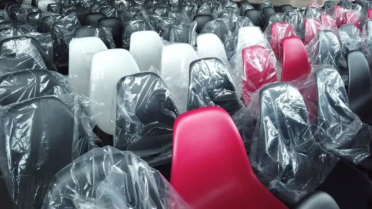 Rows of plastic black white and a few red chairs