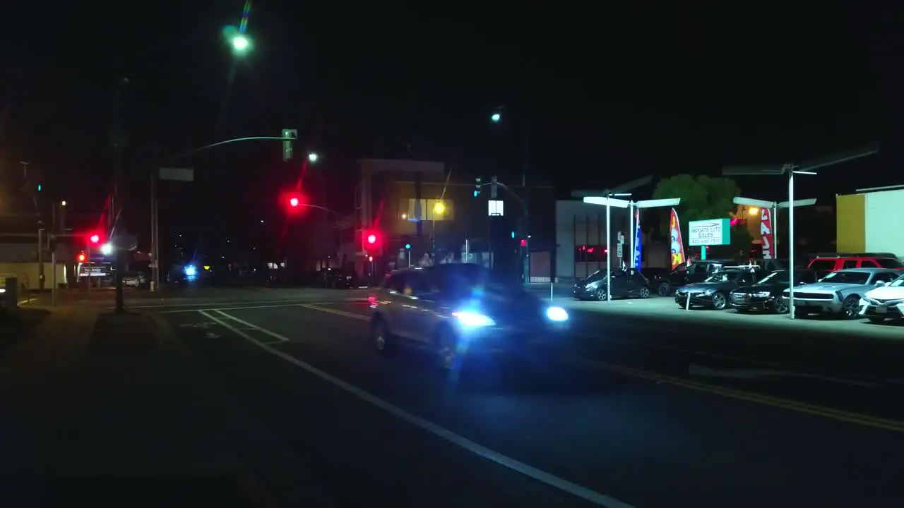 Light urban traffic at night with street lights and cars passing