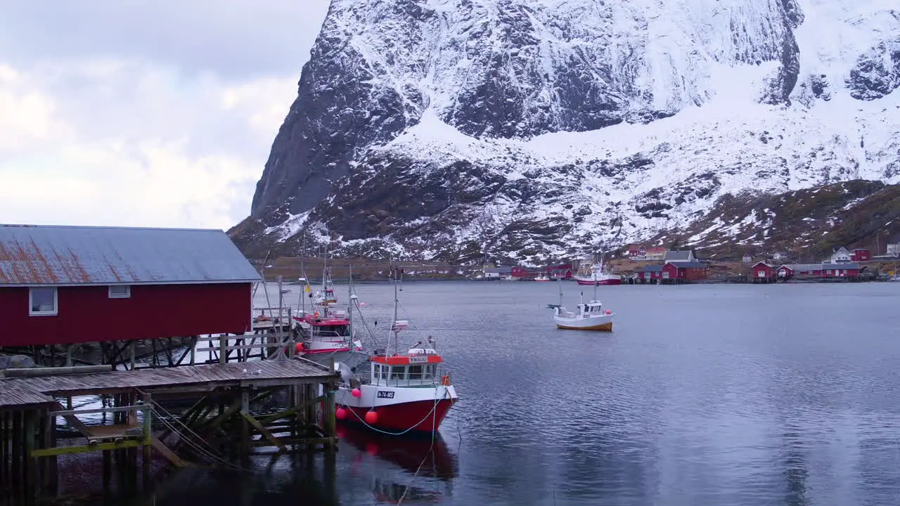 Cinematic tracking shot of a boathouse and fishing boats in Reine Lofoten