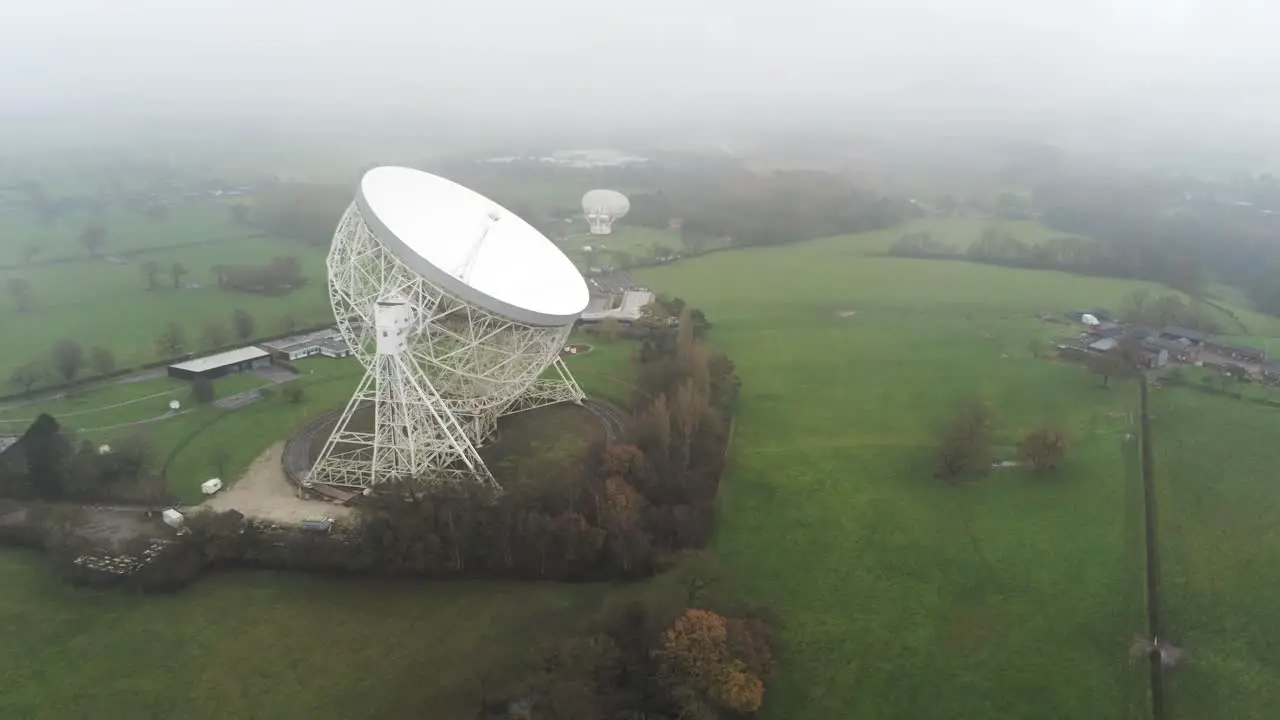 Aerial Jodrell bank observatory Lovell telescope misty rural countryside front to side orbit left