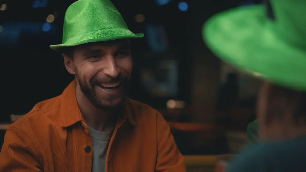 Portrait Of Happy Man In Irish Hat Talking With Friends In A Pub