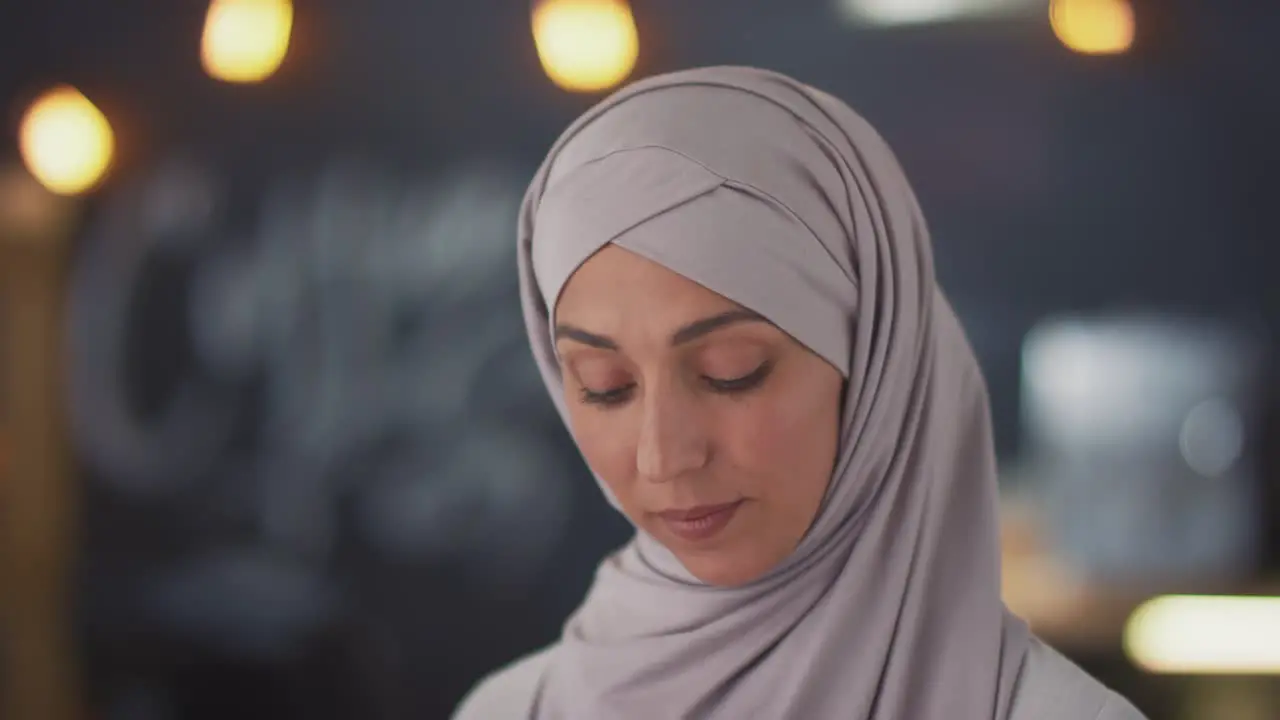 Camera Focuses On The Face Of A Muslim Waitress In A Coffee Shop