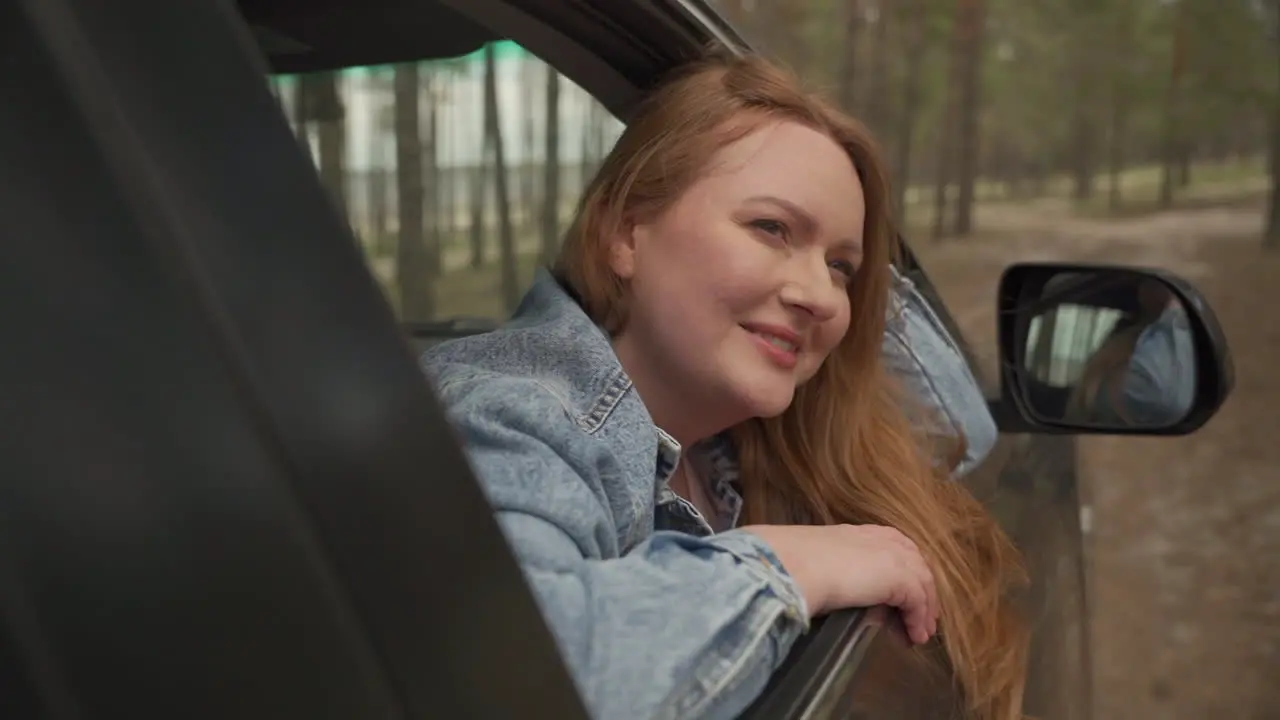 Red Haired Female Enjoys A Drive Through The Countryside From The Window Of The Car