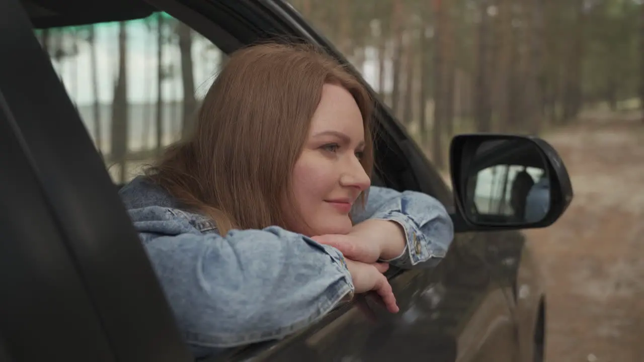 Red Haired Female Enjoys A Drive Through The Countryside From The Window Of The Car 1