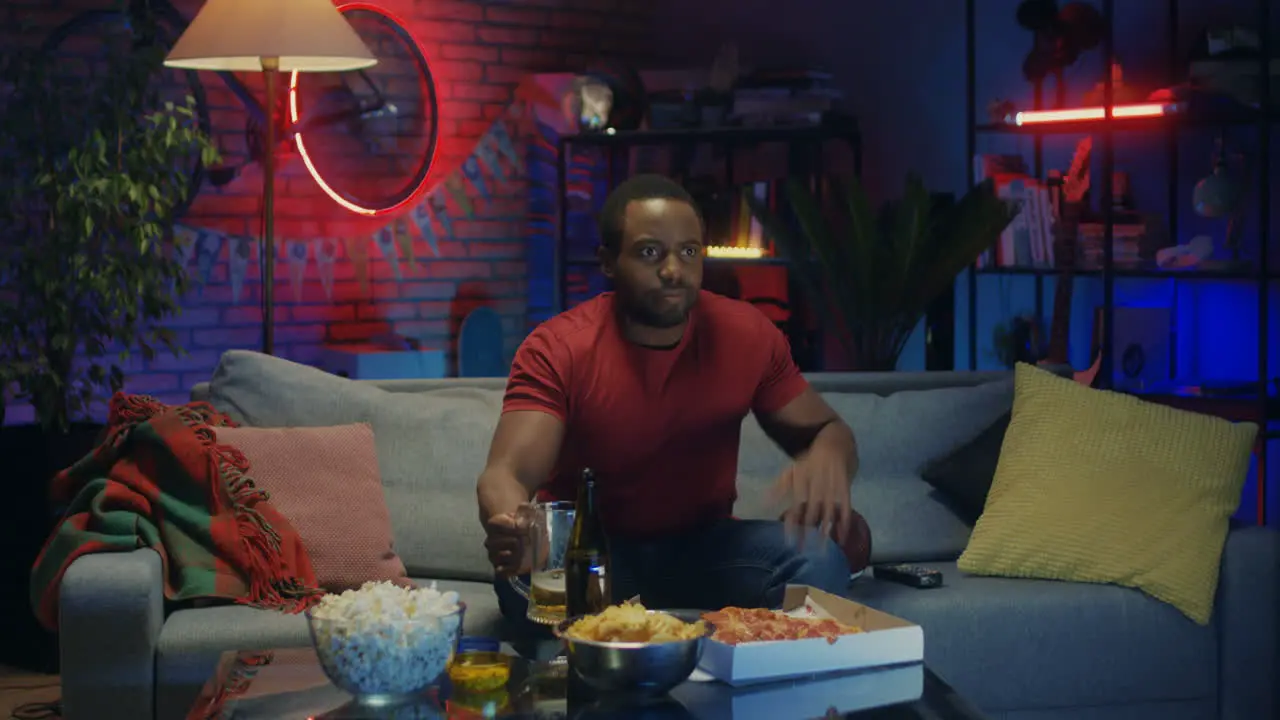 Male Sport Fan Watching Football Game On Tv In The Evening And Drinking Beer