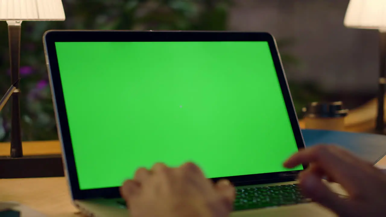 Man hands working on green screen computer