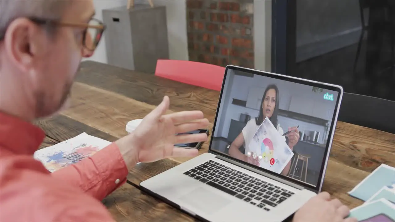 Caucasian businessman on laptop video call with african american female colleague on screen