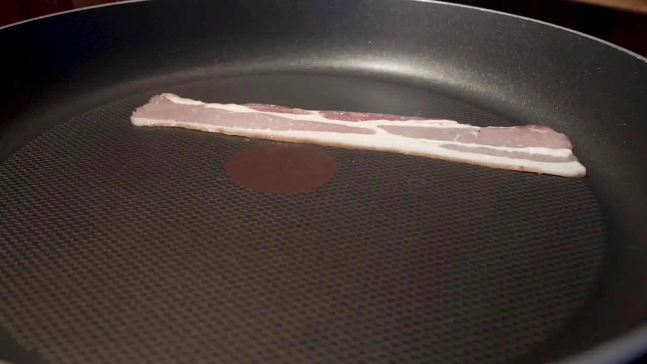 Static Close Up Shot of Sliced Bacon Cooking in a pan