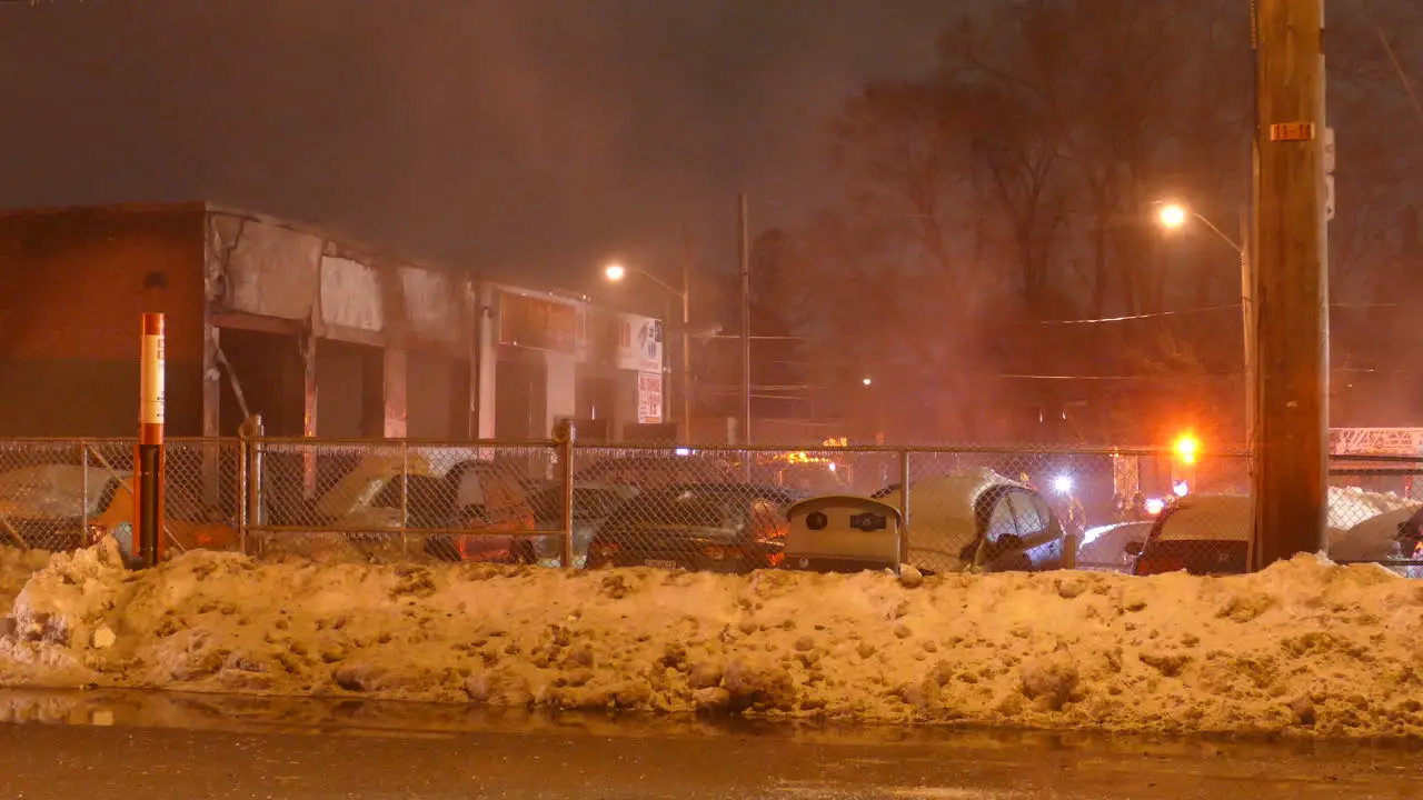 Blinking emergency lights of firefighter team near burn building night time