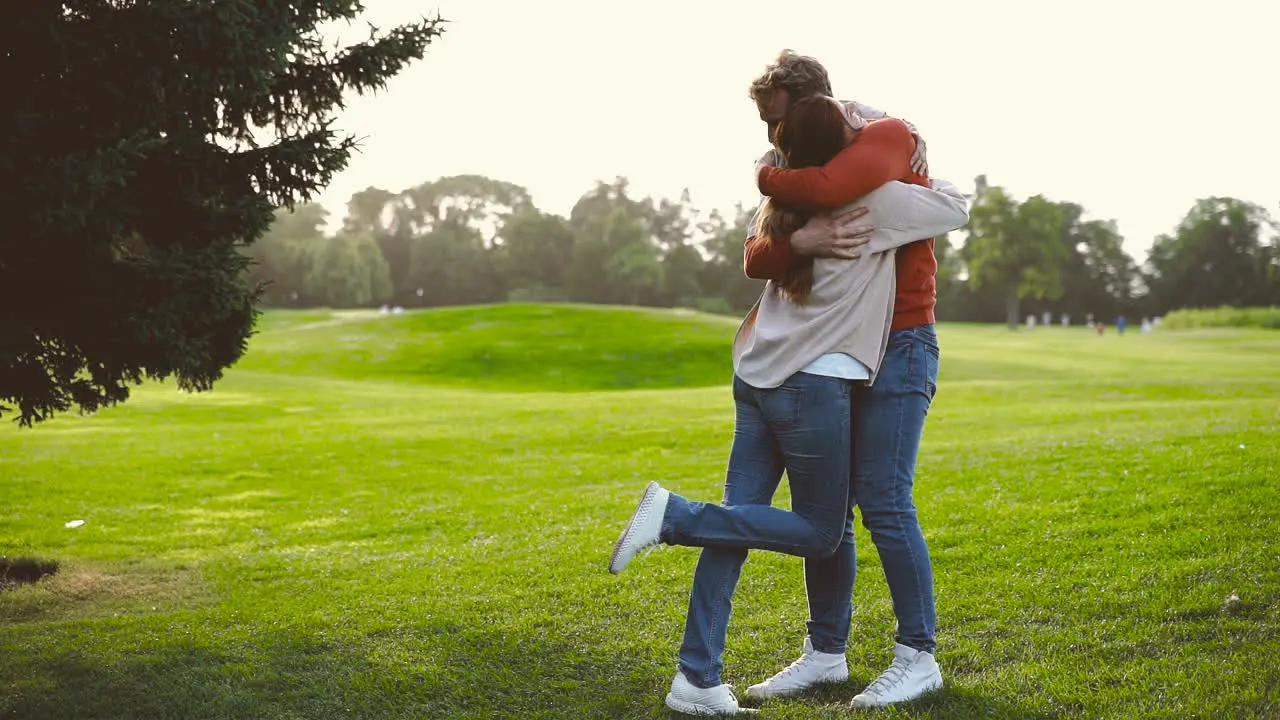 Happy Couple Spinning Around And Then Hugging In The Park