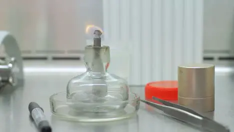 Candle stick with fire on laboratory table Fire flame in lab beaker