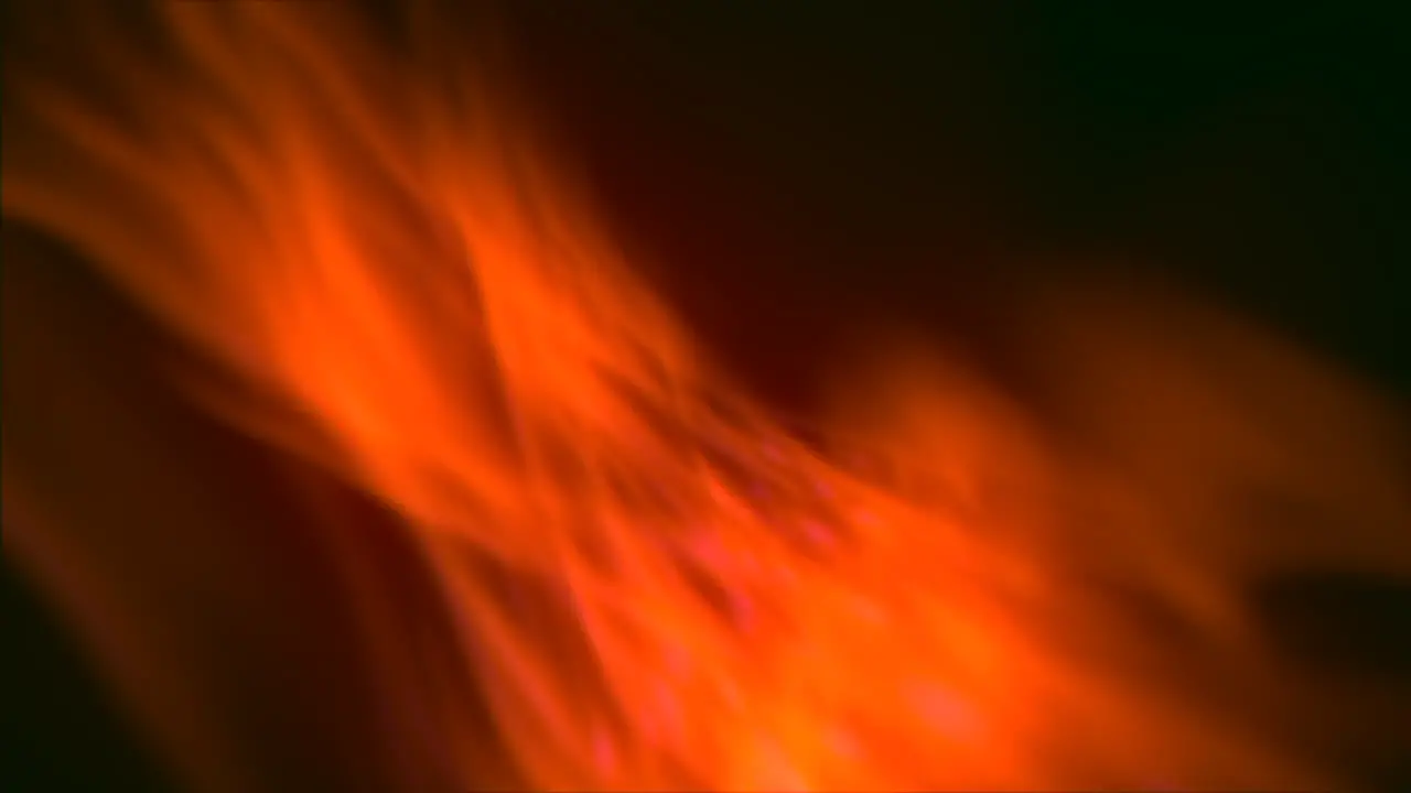 Vibrant orange flame dancing in the wind against black background