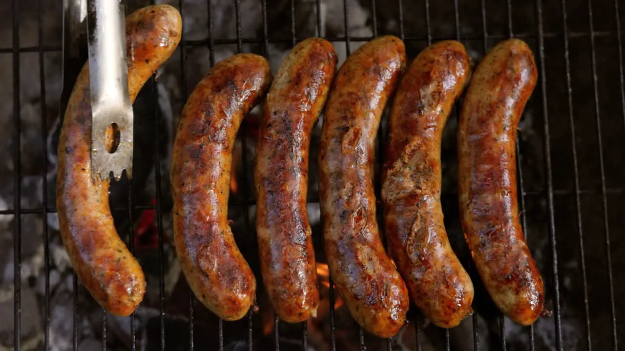 Delicious juicy sausages cooked on the grill with a fire