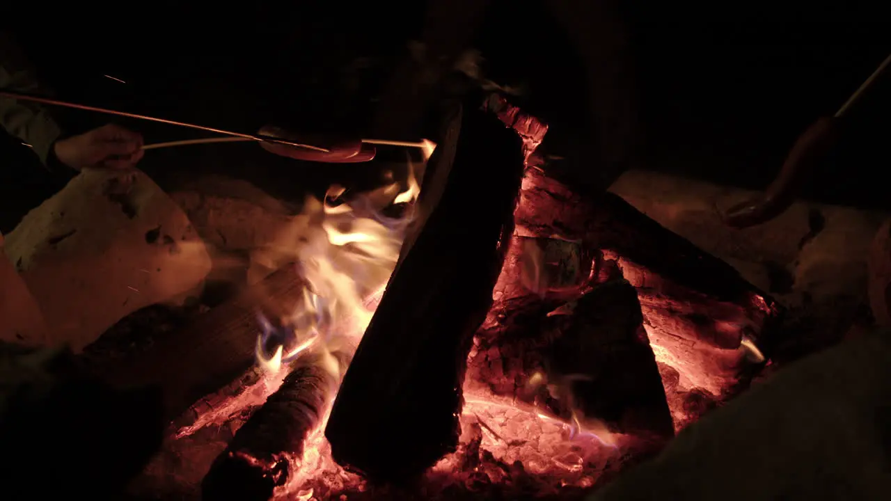 Hot Dogs and Sausages being roasted on a campfire slow motion