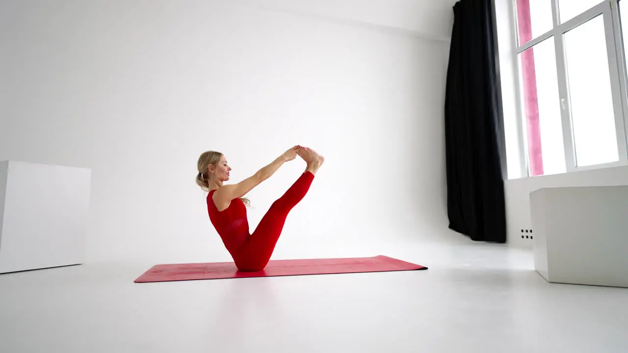 Young woman shows yoga or pilates exercises Young attractive woman practicing yoga in studio Girl shows different poses for yoga in white background Healthy lifestyle yoga in my heart sports