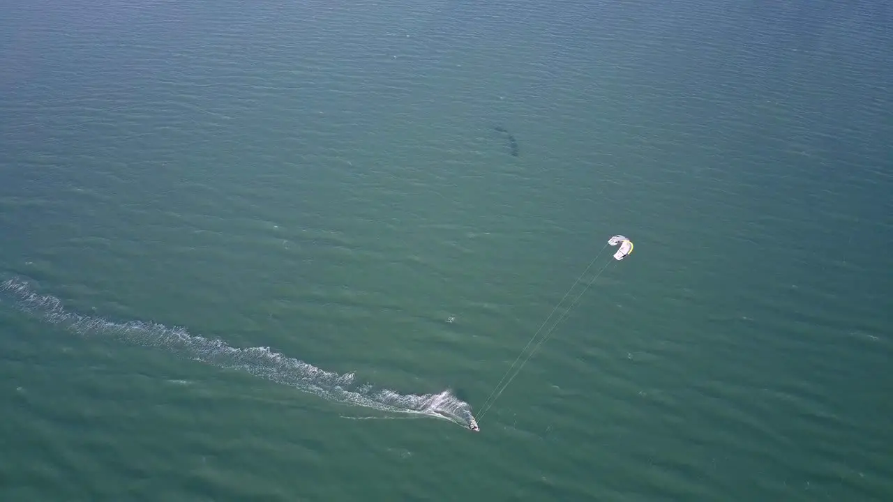 Drone shot of a kiteboarder surfing on the coast of Ilha do Guajiru Brazil