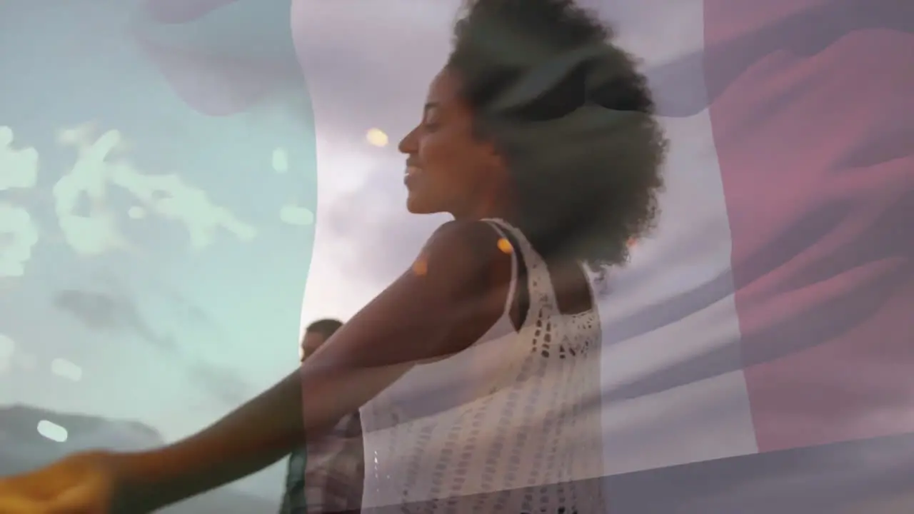 Animation of flag of italy over happy diverse couple dancing with sparklers on beach at dusk