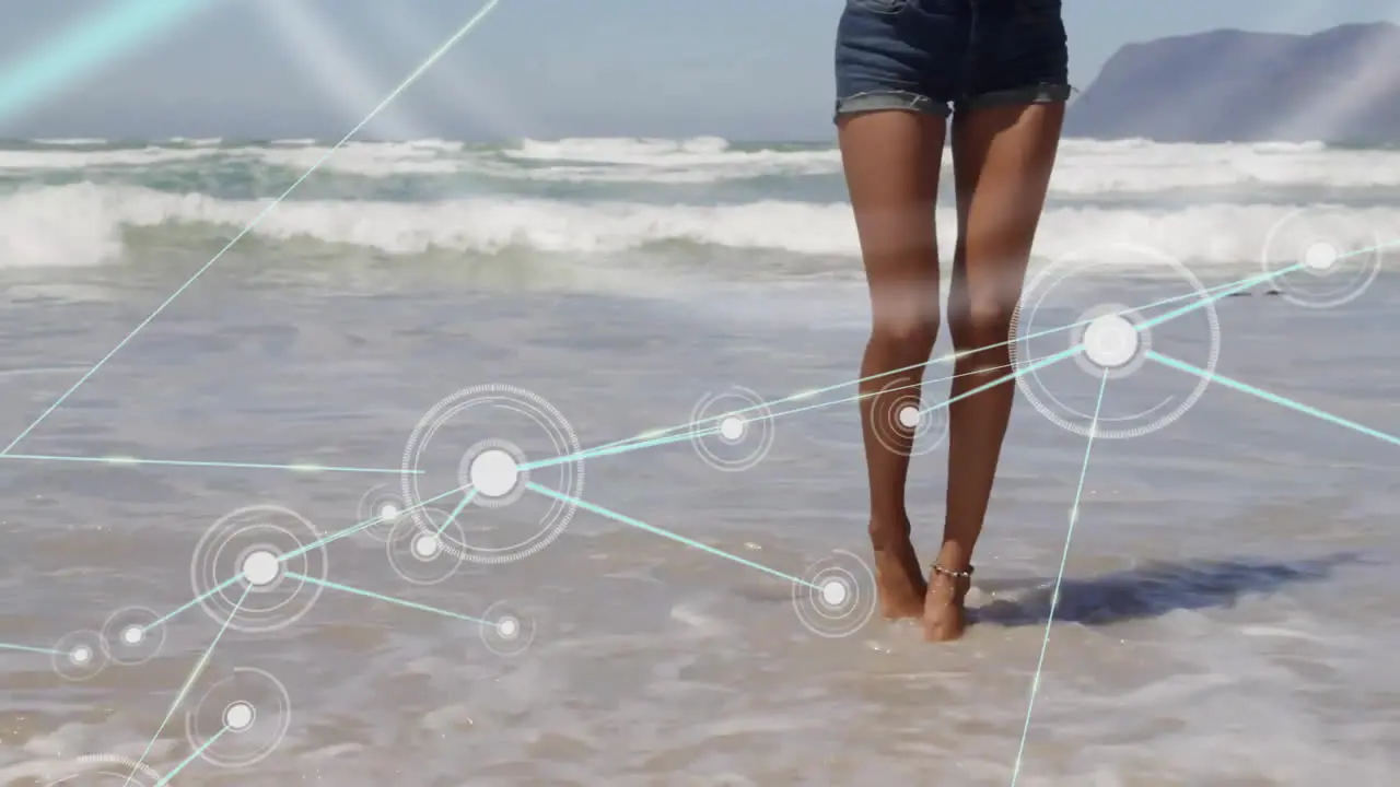 Animation of network of connections with icons over biracial woman by sea