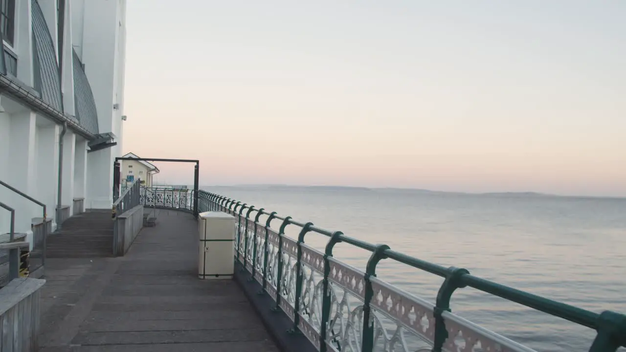 Walking Out Along Penarth Pier In Wales At Dusk