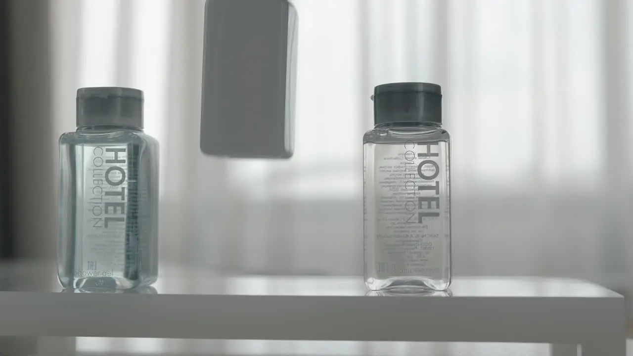 A closeup of three cosmetics bottles being put on a table