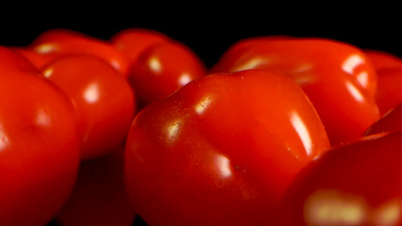 Extreme Close-Up slide on red Cherry Tomatoes on a black table