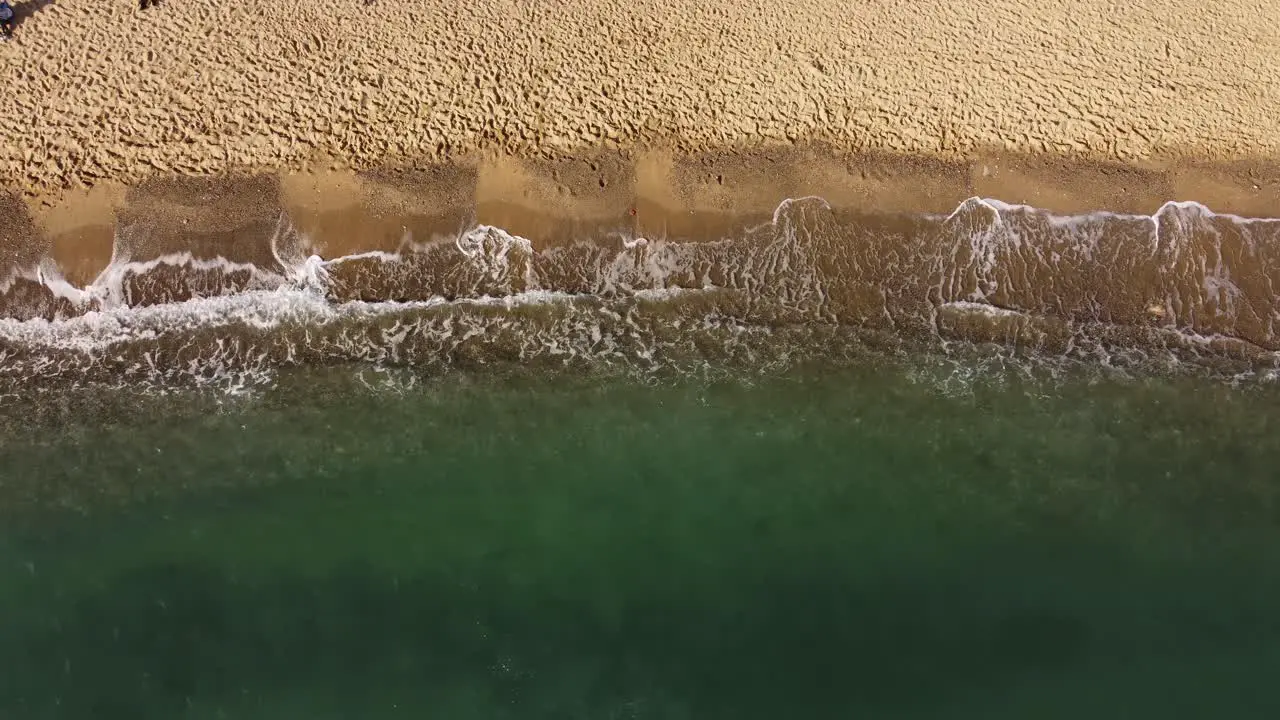 Calming ocean waves crashing on shore overhead aerial