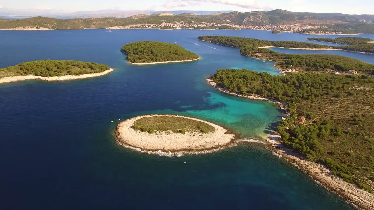 Drone moving away from 2 kayaks and revealing blue lagoon with small islands