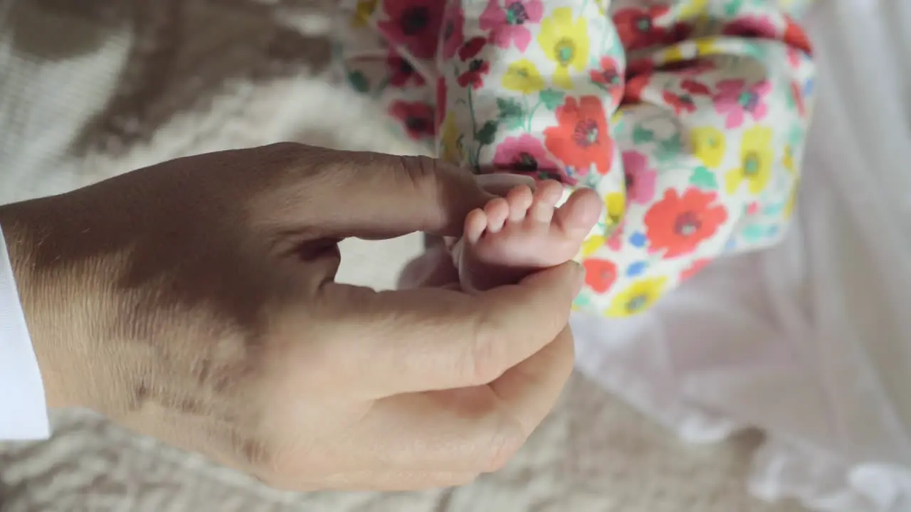 Grandpa holding small foot of baby grandchild