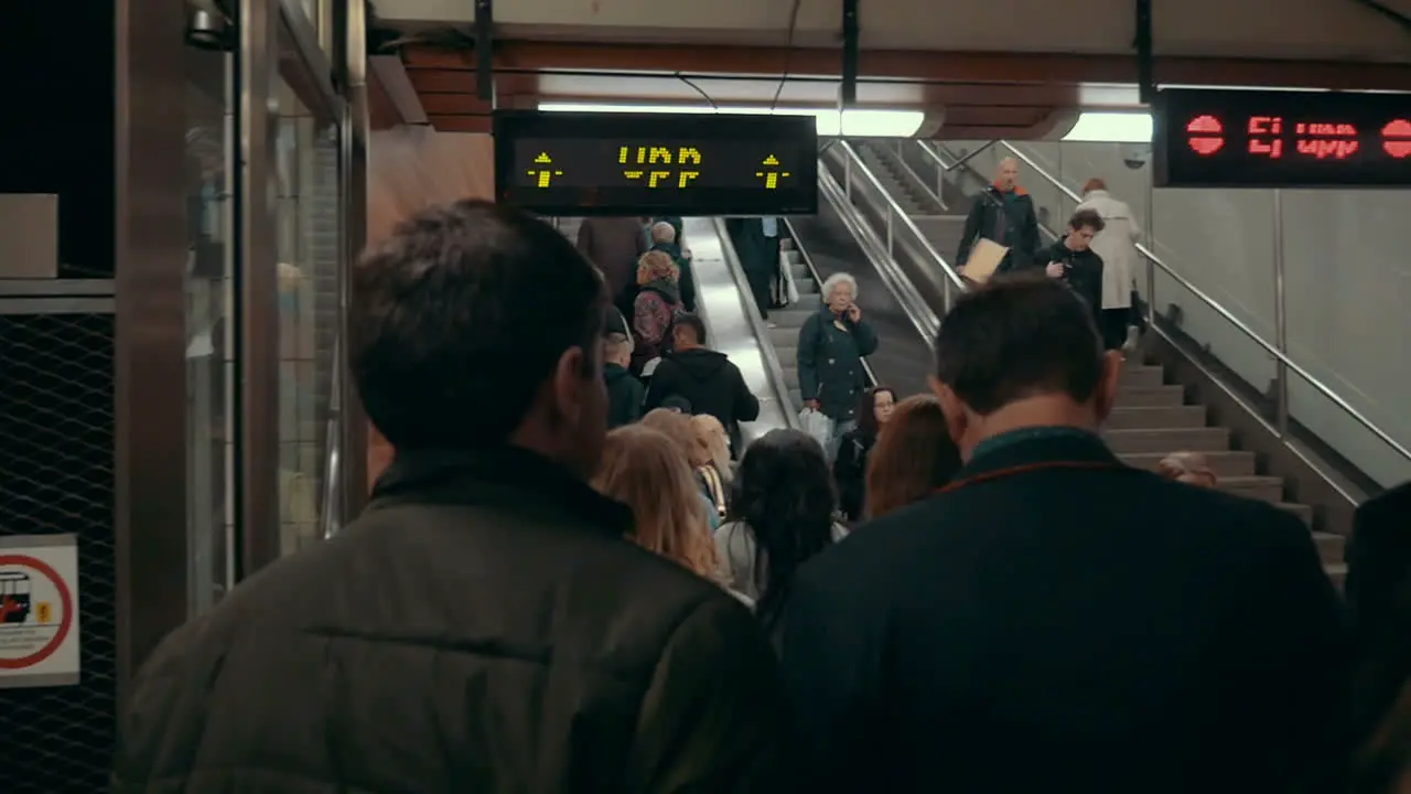 People riding up and down escalators in subway