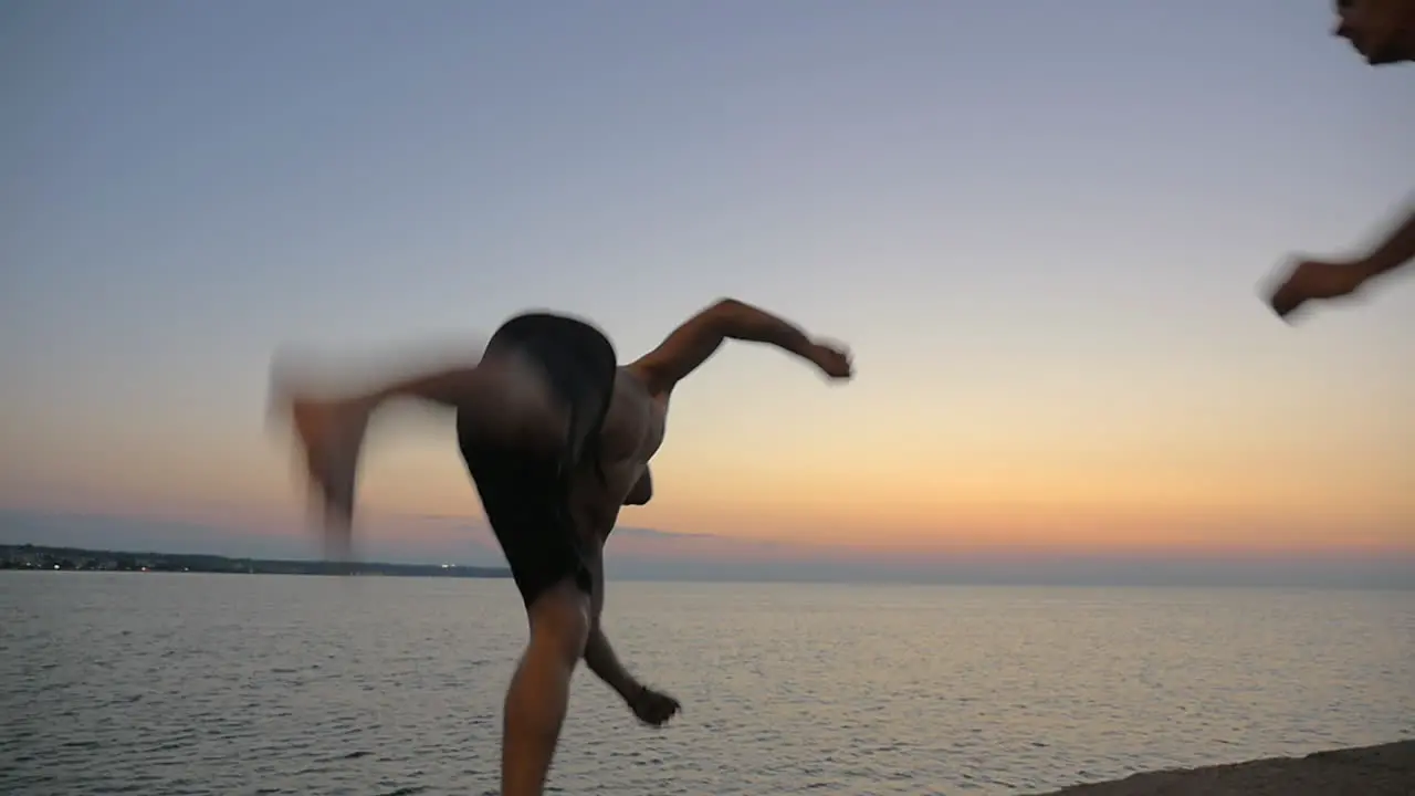 Two young guys doing tricks jumping from pier